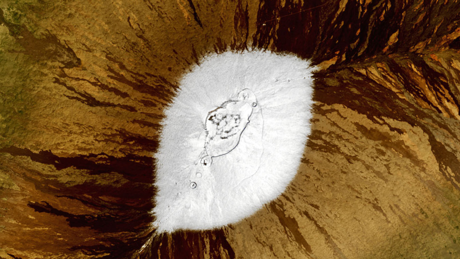 A satellite photo showing snow at the top of a mountains from above