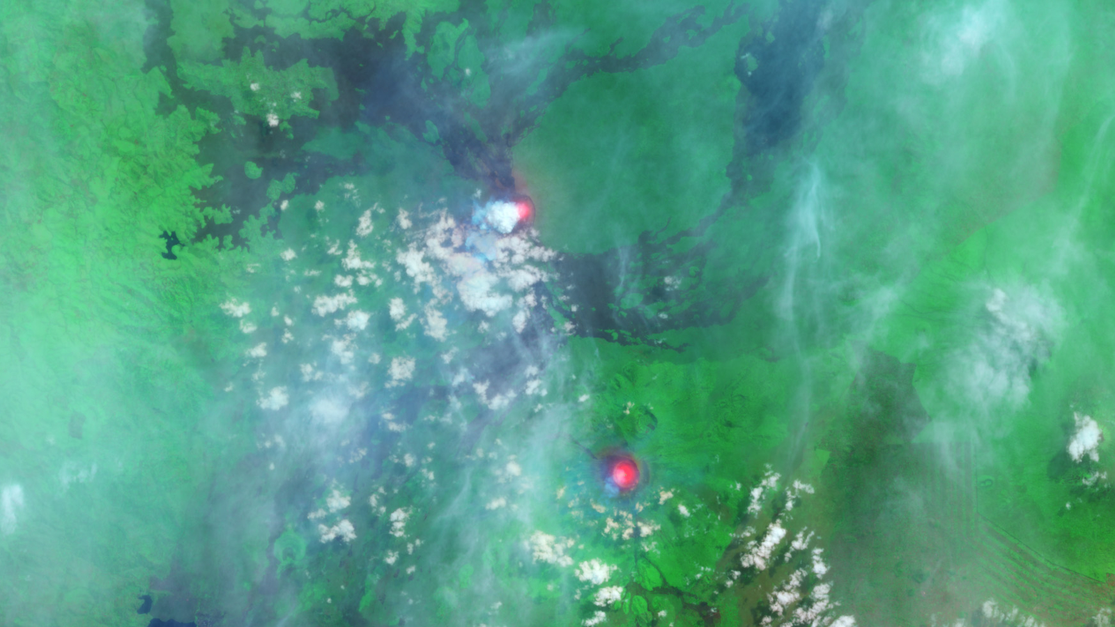 A satellite photo showing two bright red spots in a green landscape